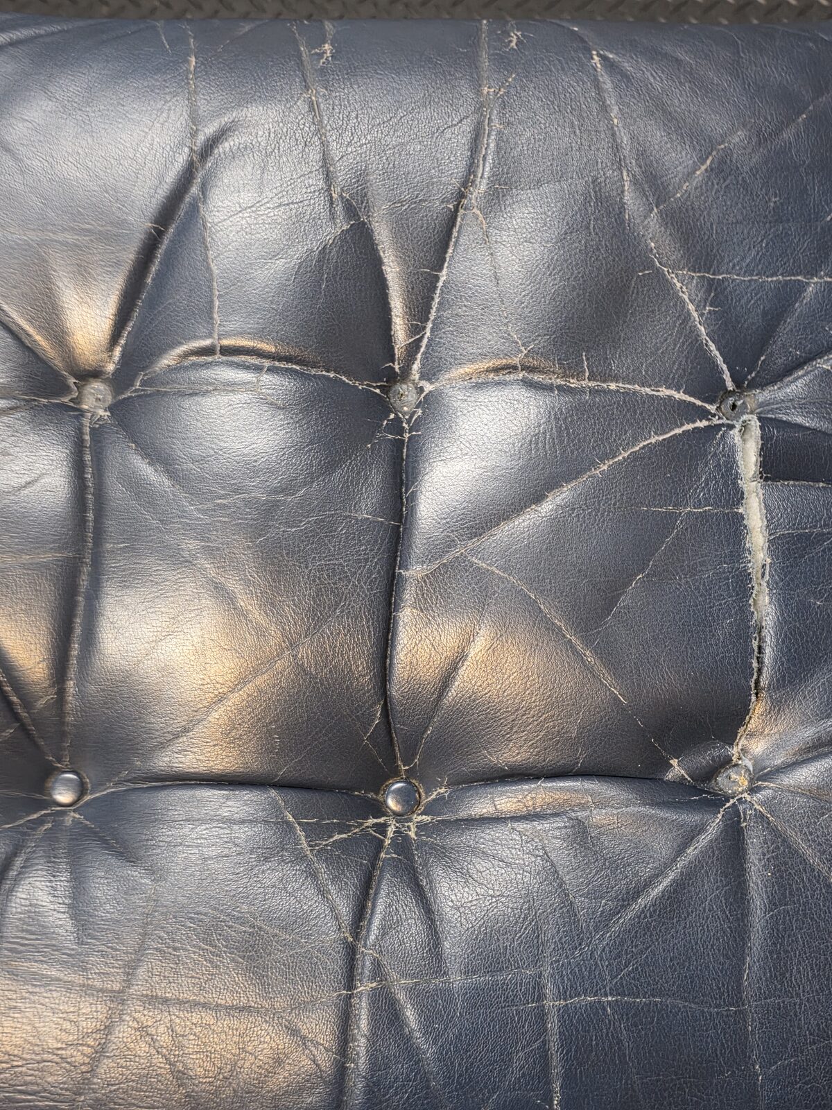 Hand-stitching repair in progress on leather upholstery