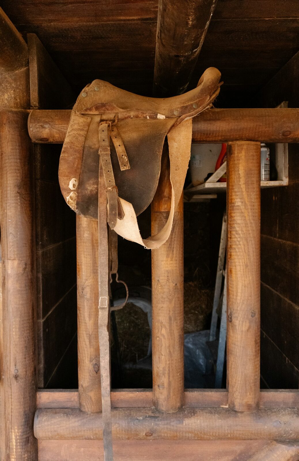 Leather saddle hanging in a stable