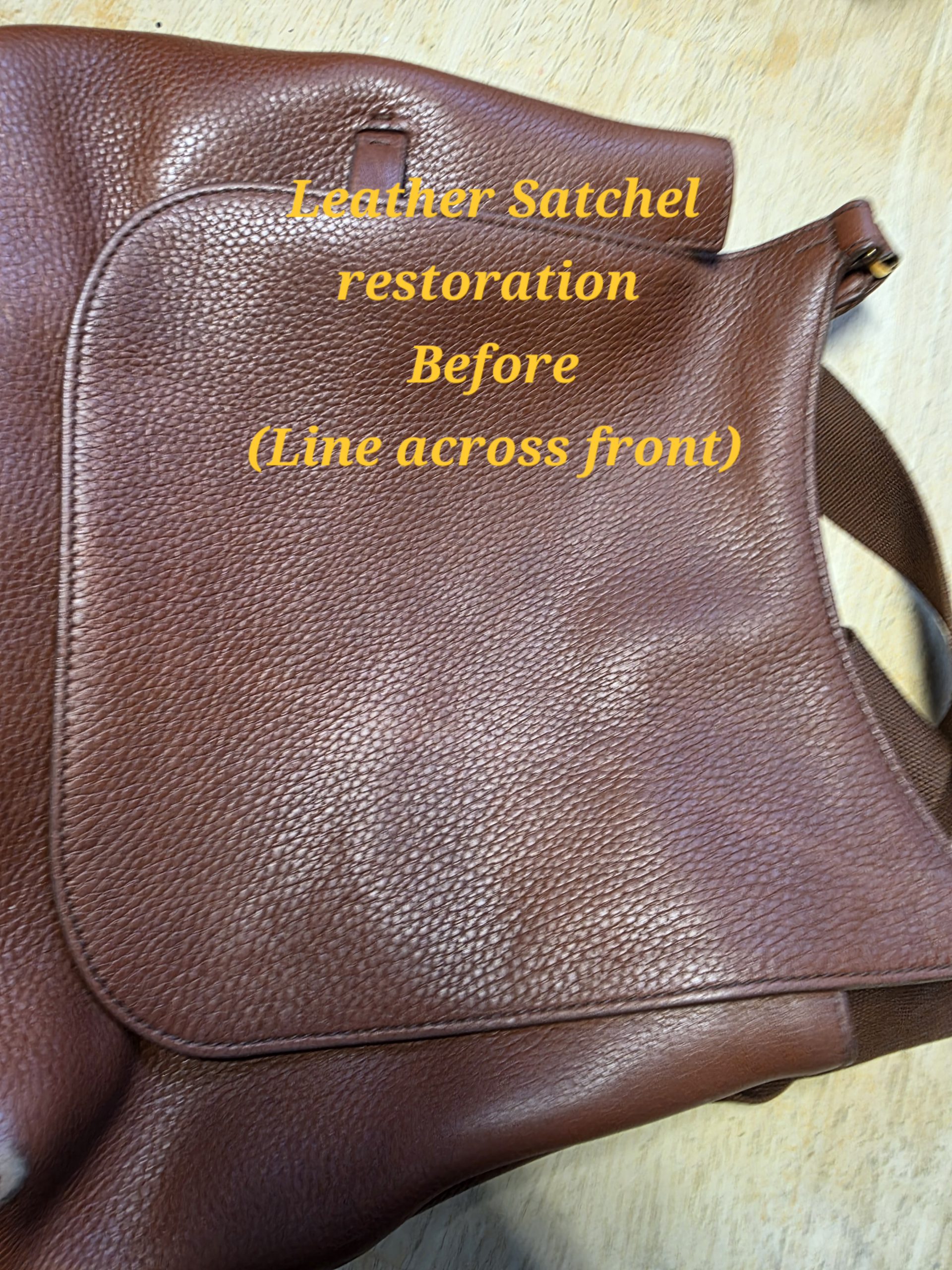 Leather satchel with crease line before restoration